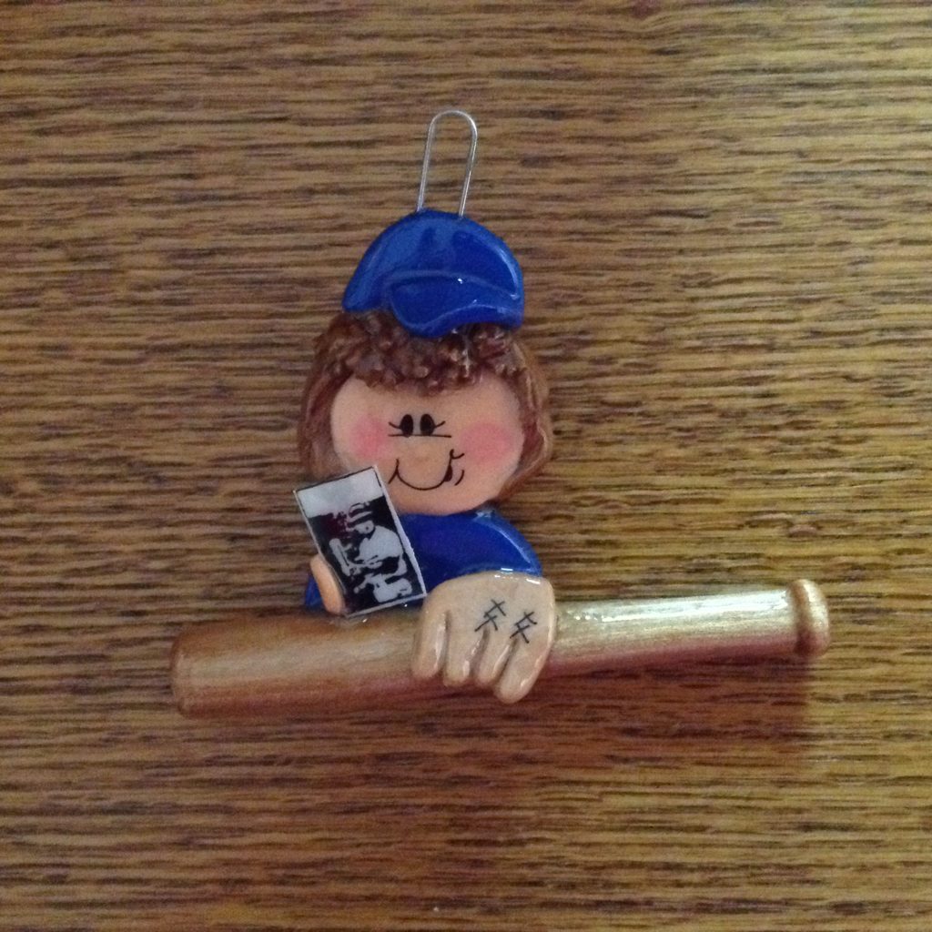 A baseball player ornament hanging on the wall.
