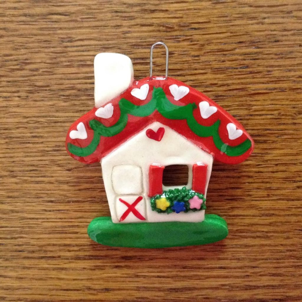 A christmas ornament that is shaped like a house.