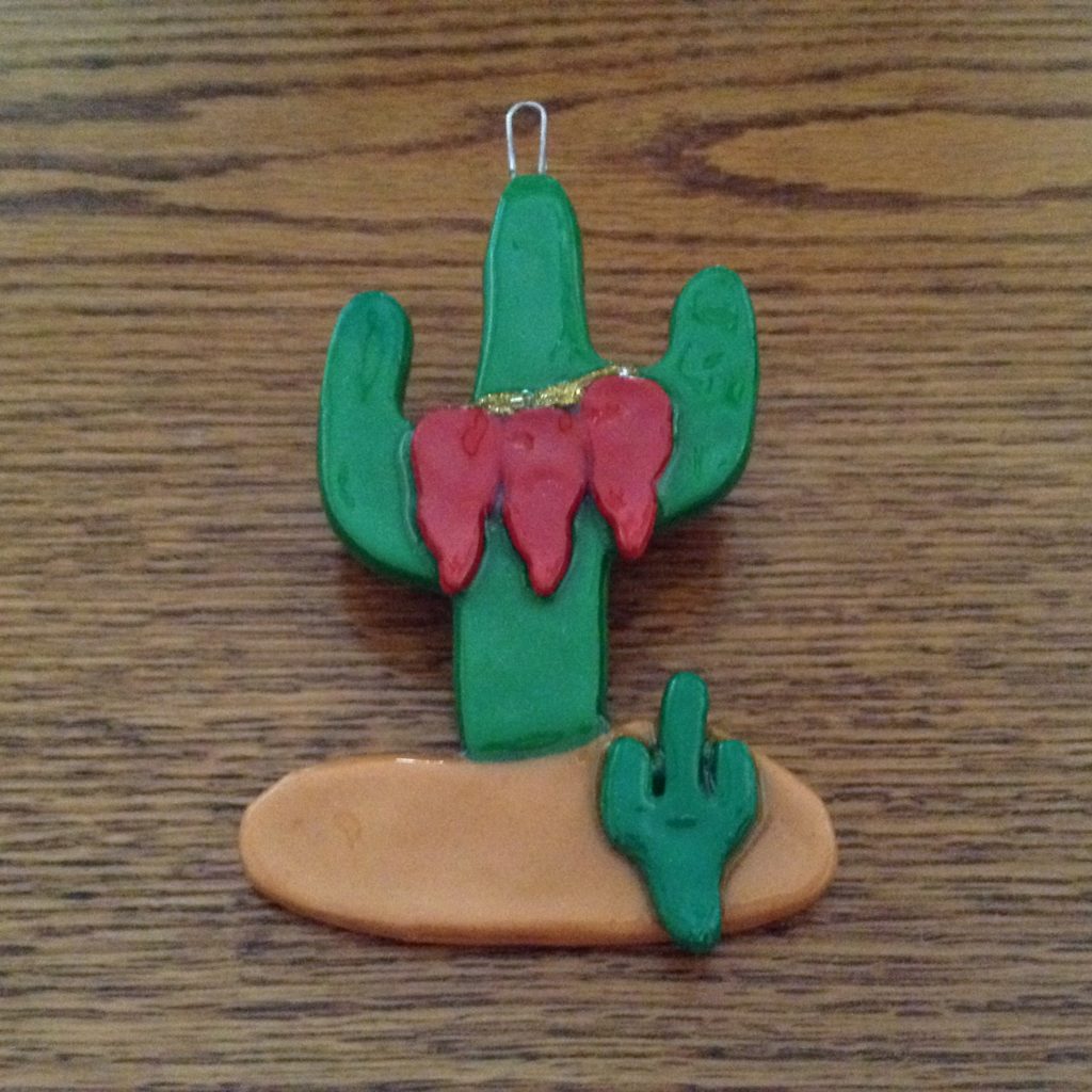 A cactus and a surfboard are on the table.