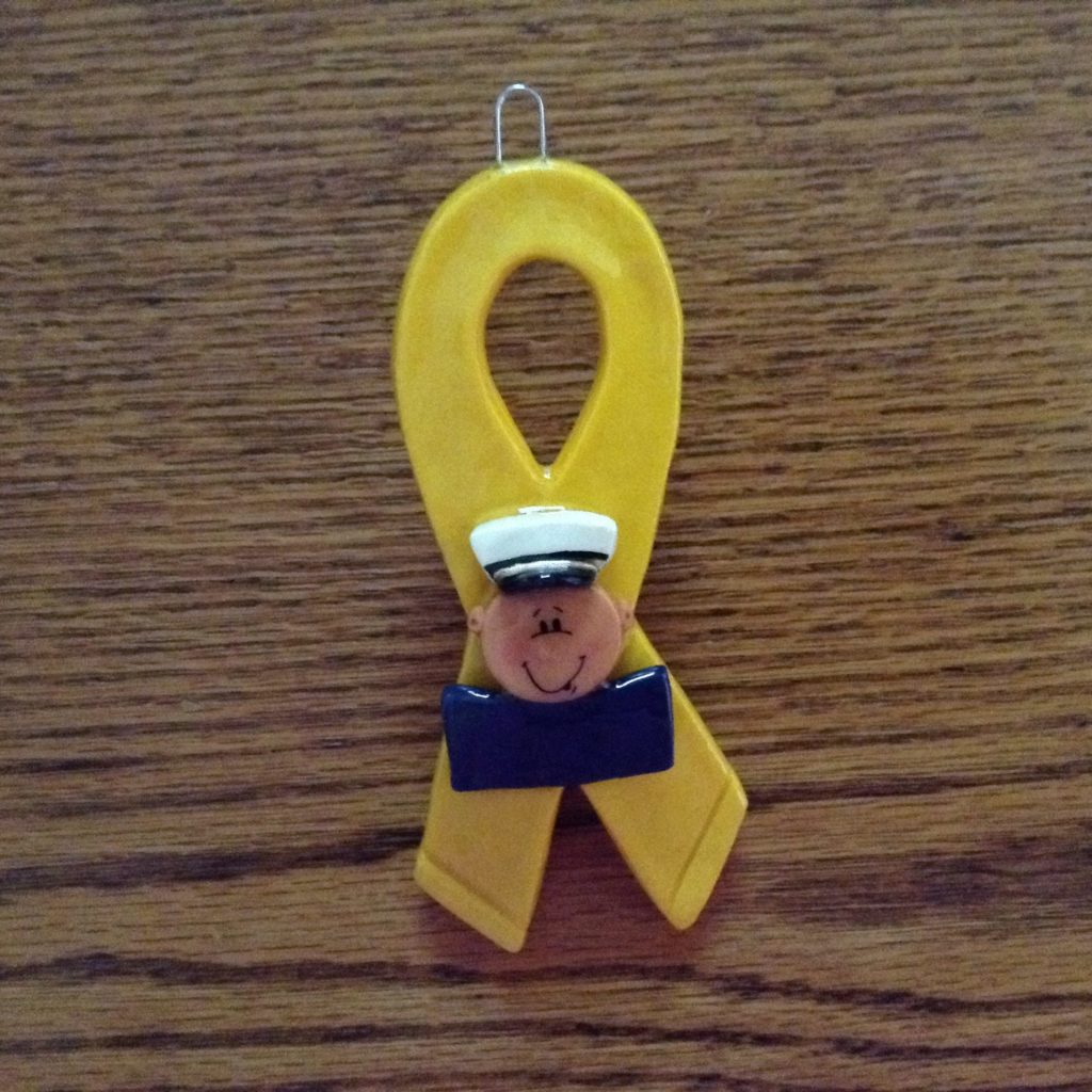 A yellow ribbon with a sailor 's face on it.