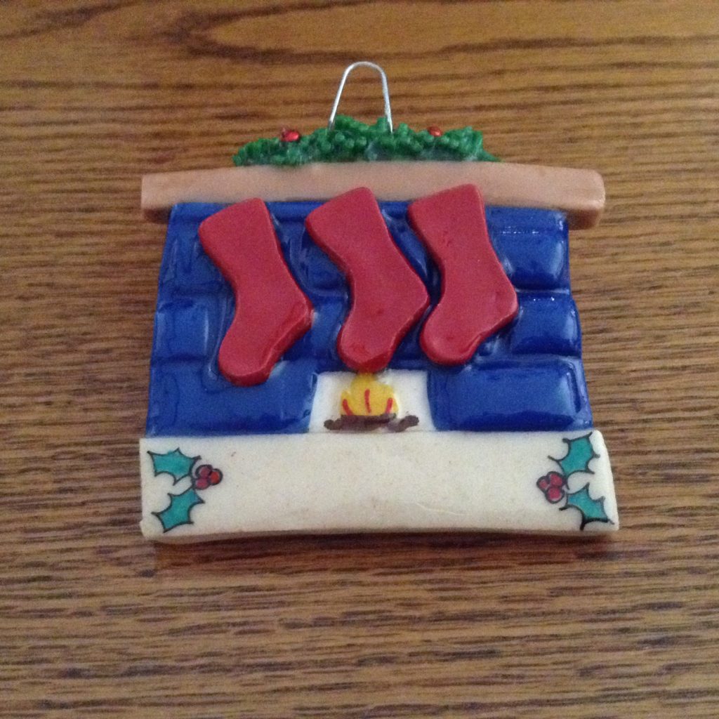 A christmas ornament with three stockings on it.