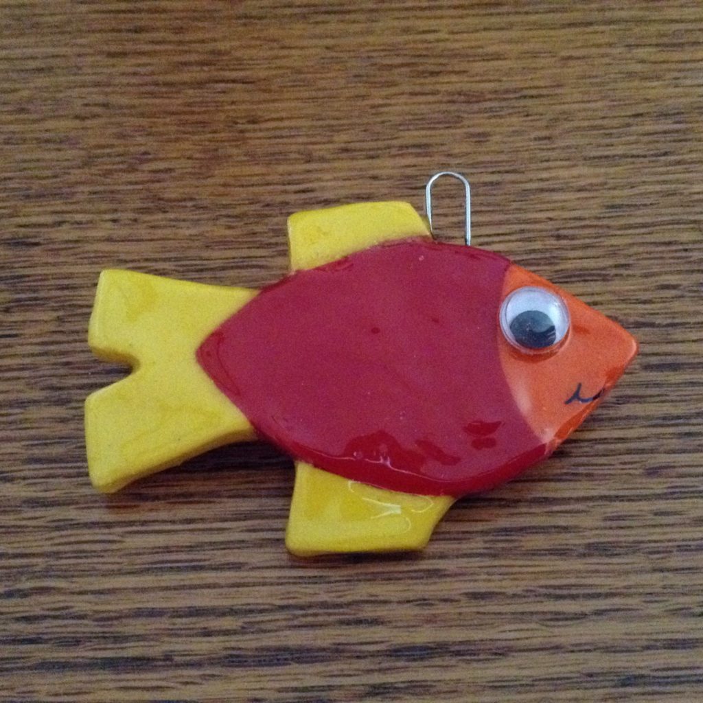 A red and yellow fish ornament with googly eyes.