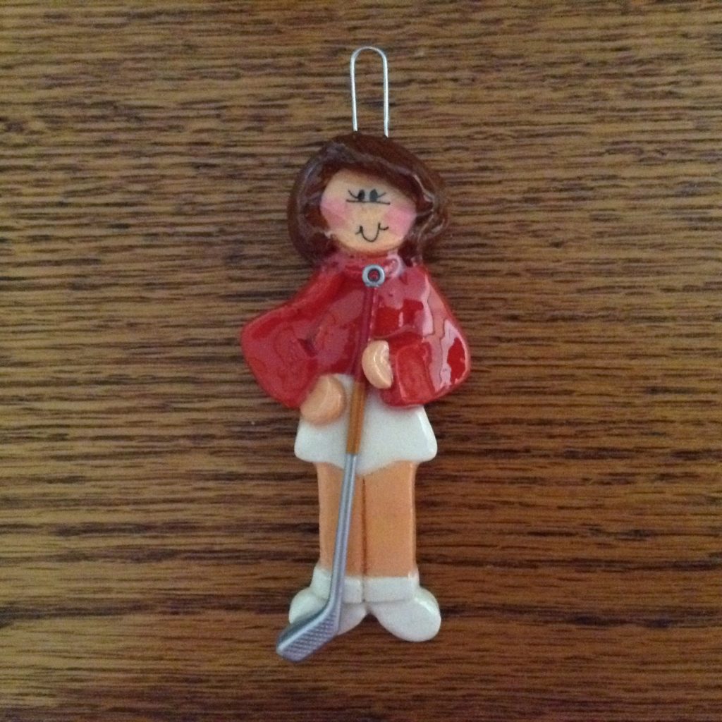 A wooden figure of a woman holding an ice hockey stick.