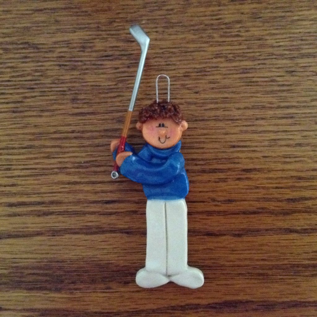 A small figurine of a man holding a golf club.