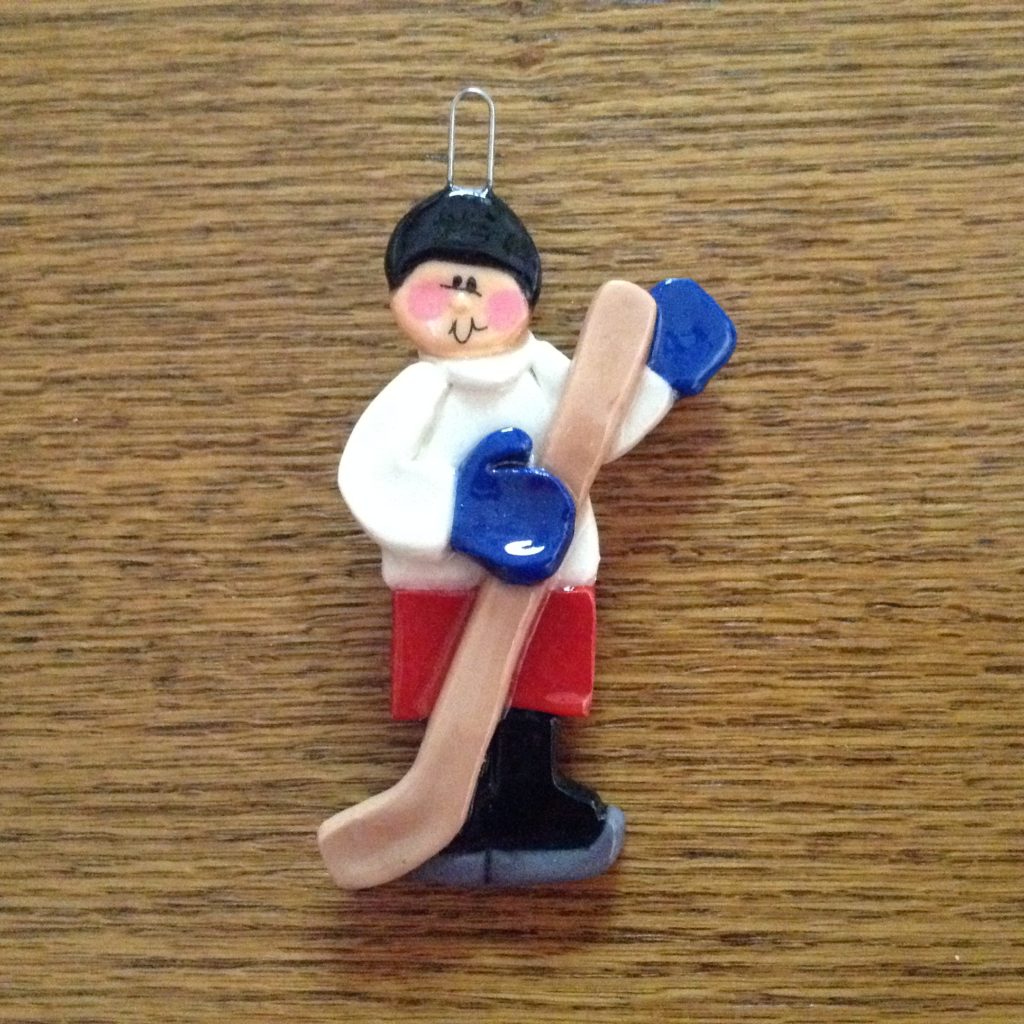 A wooden table with a christmas ornament of a hockey player.