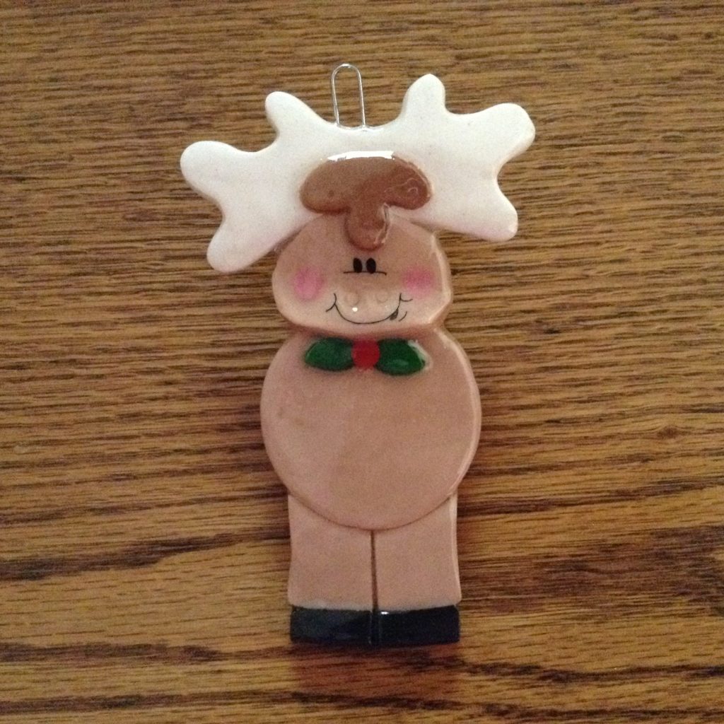 A close up of a toy reindeer on top of a table.