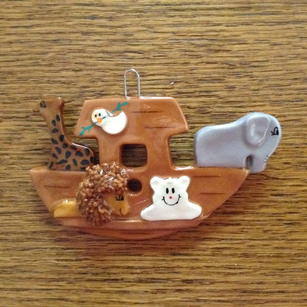 A wooden toy boat with animals on it.