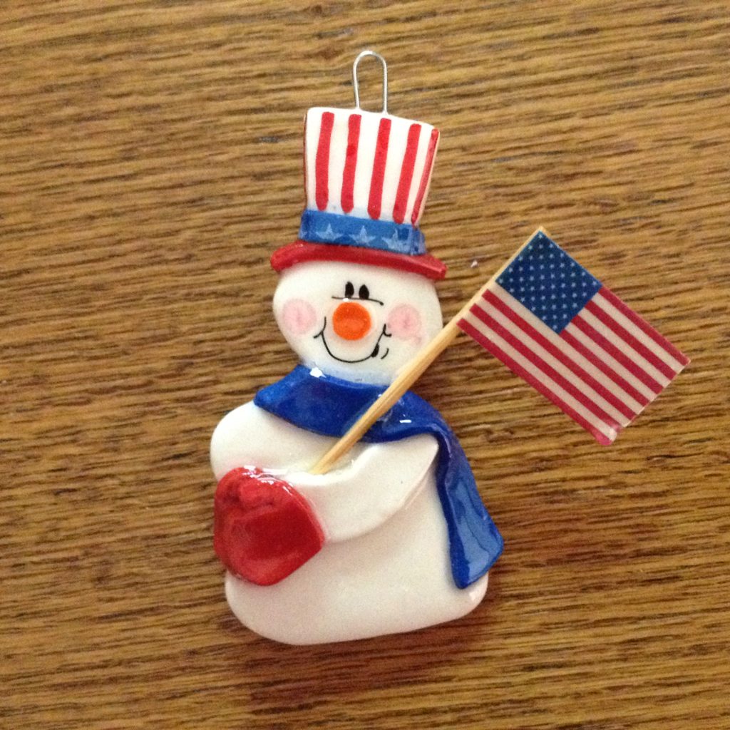 A snowman with an american flag on it's head.