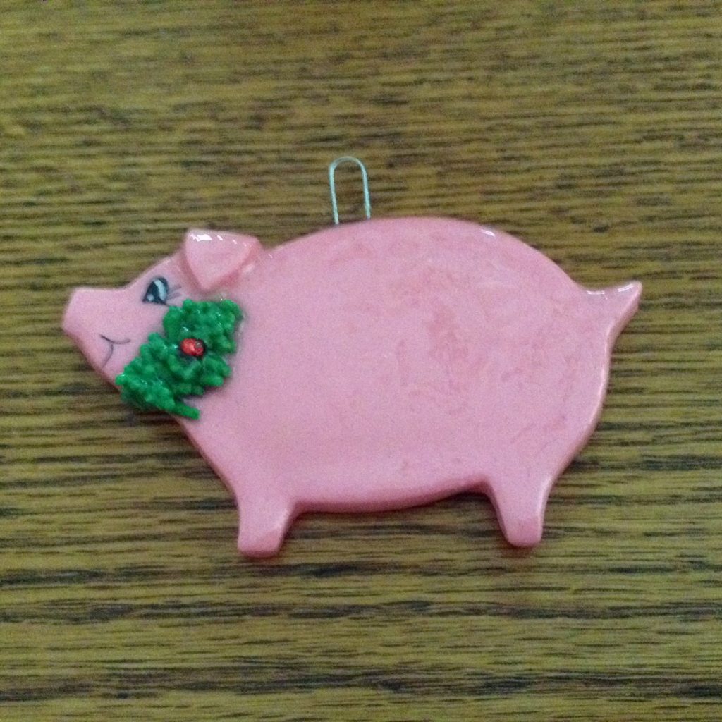 A pink pig with a green bow on it's head.