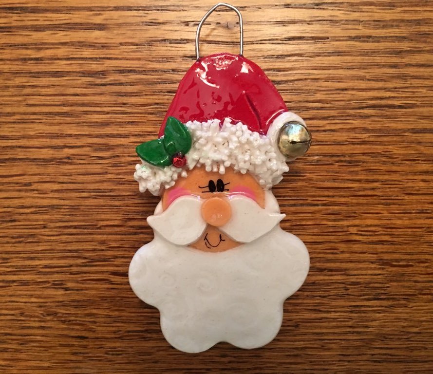 A santa clause ornament is hanging on the table.