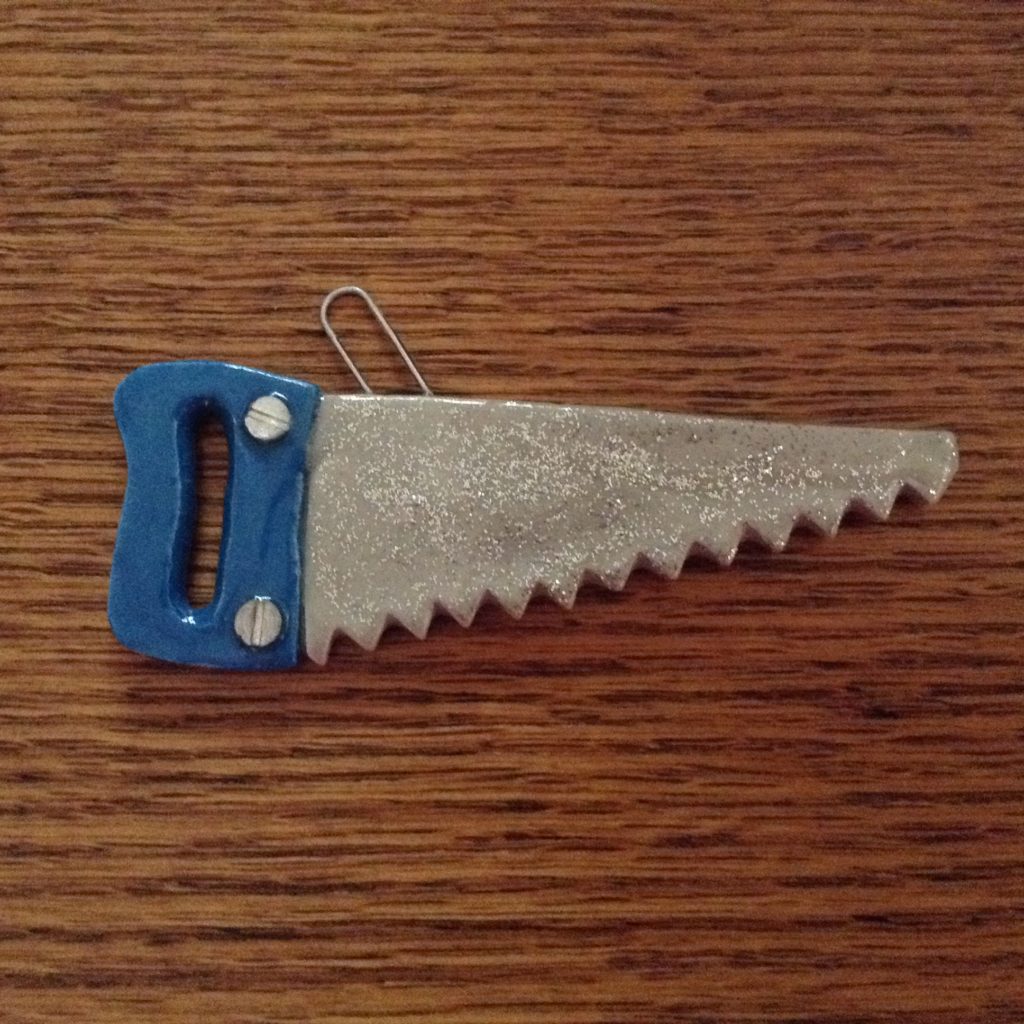 A blue and silver saw on top of a wooden table.