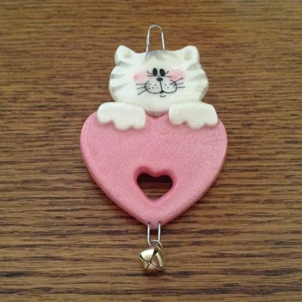 A cat ornament hanging on the wall