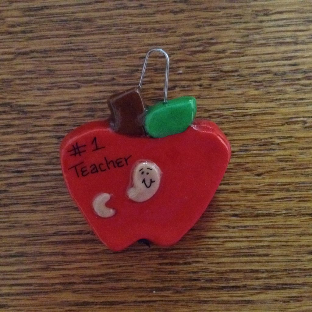 A red apple with the words " i teacher " written on it.
