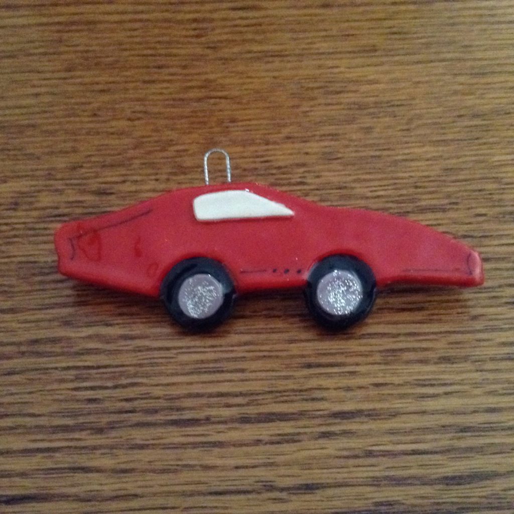A red car ornament is sitting on the table.