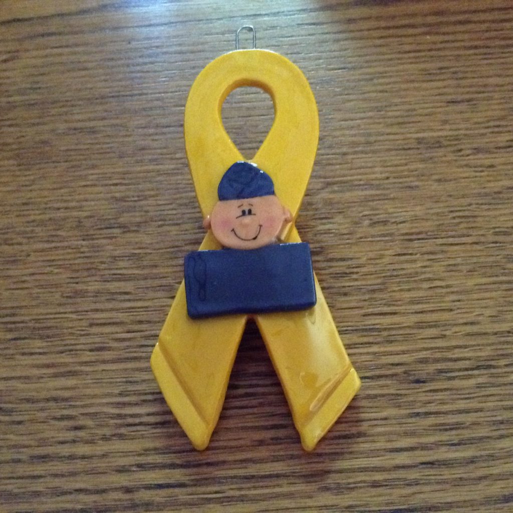 A yellow ribbon with a man 's face on it.