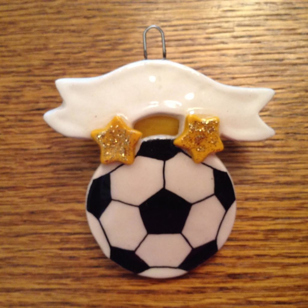 A soccer ball ornament with two stars on it.