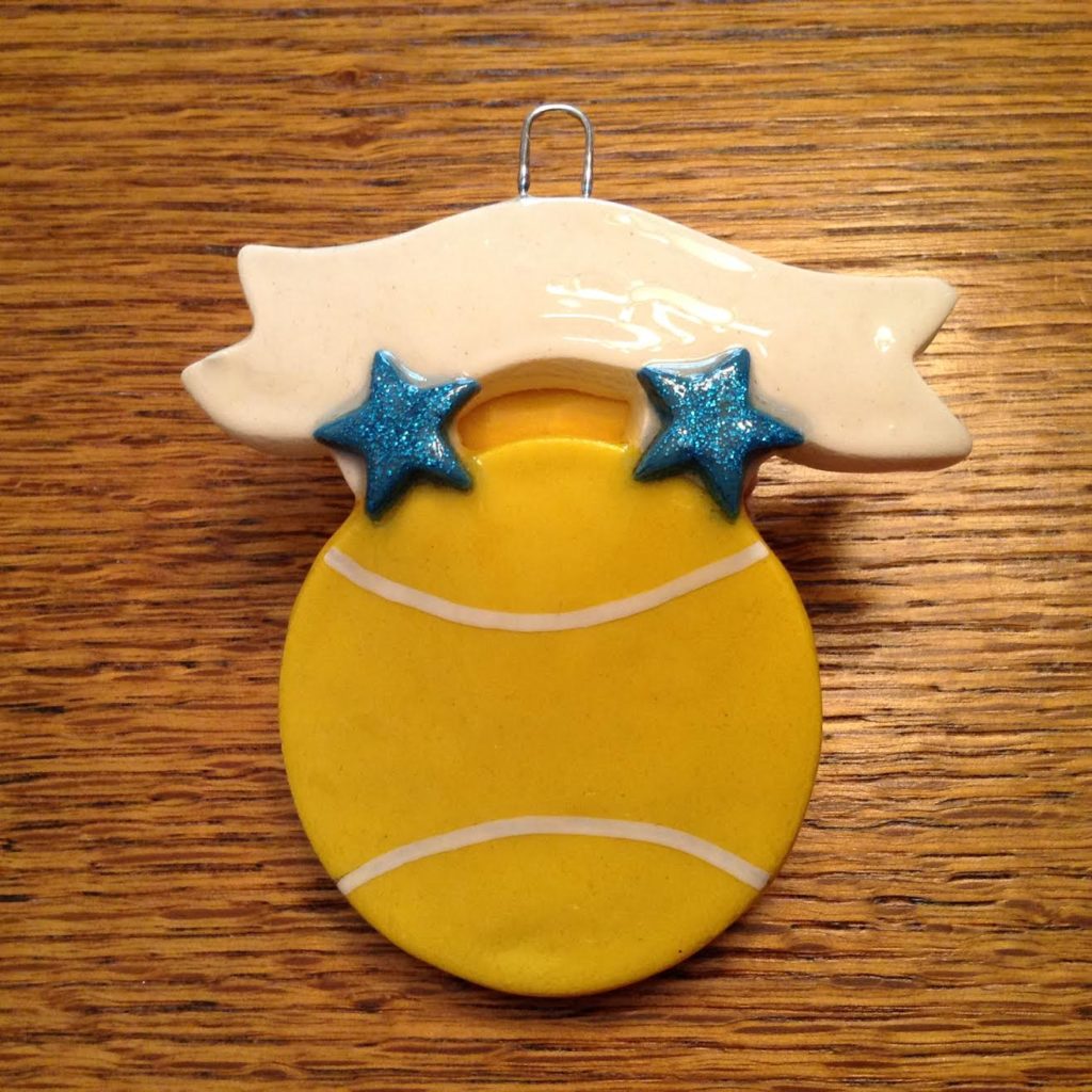 A tennis ball ornament with two stars on it.