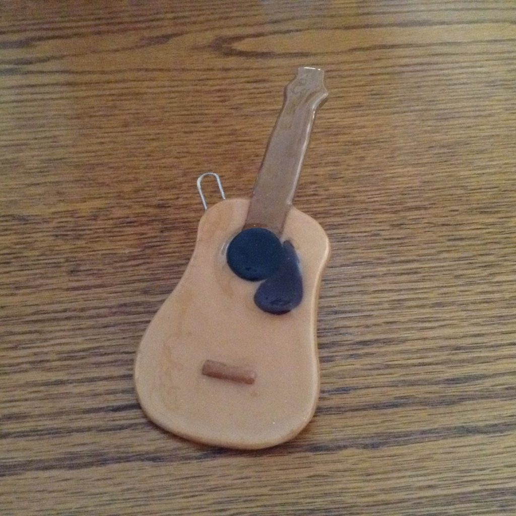 A wooden guitar key holder sitting on top of a table.