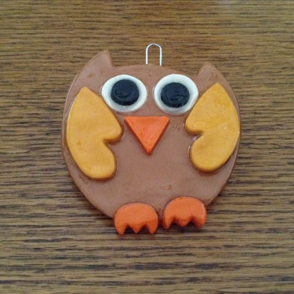 A brown owl ornament sitting on top of a table.
