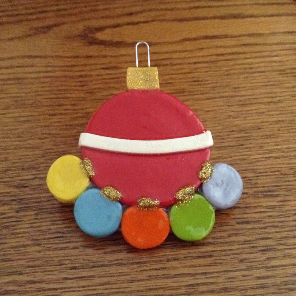 A red ornament with four colored buttons on it.