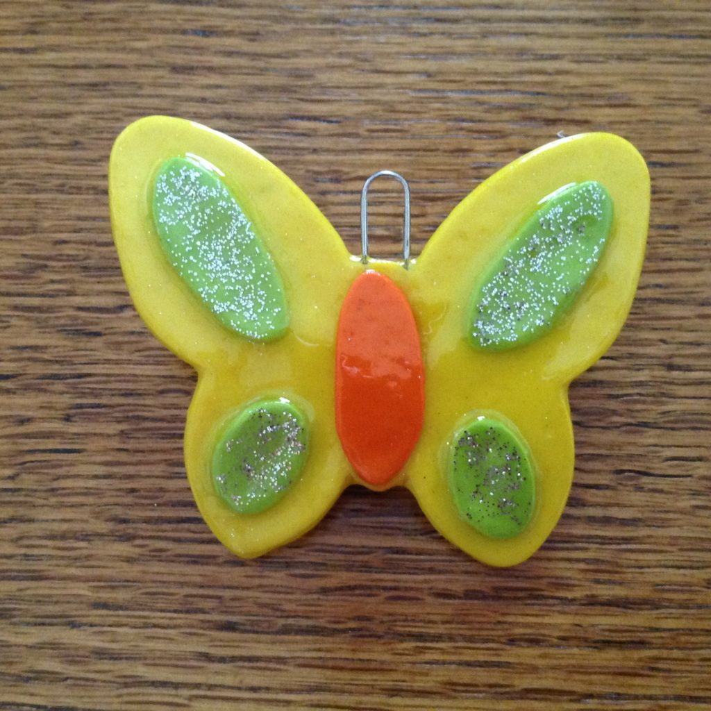 A yellow butterfly with green and orange wings.