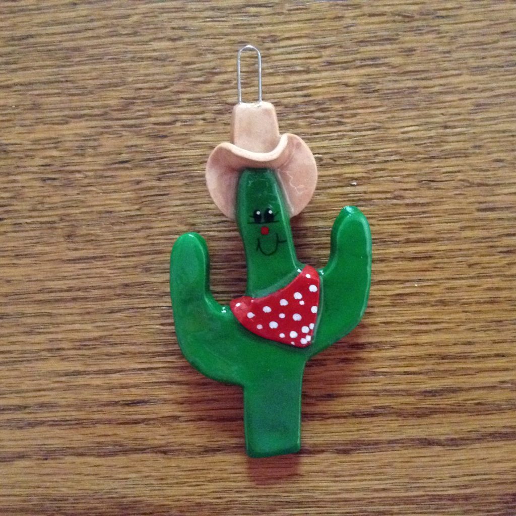 A cactus with a cowboy hat on it's head.