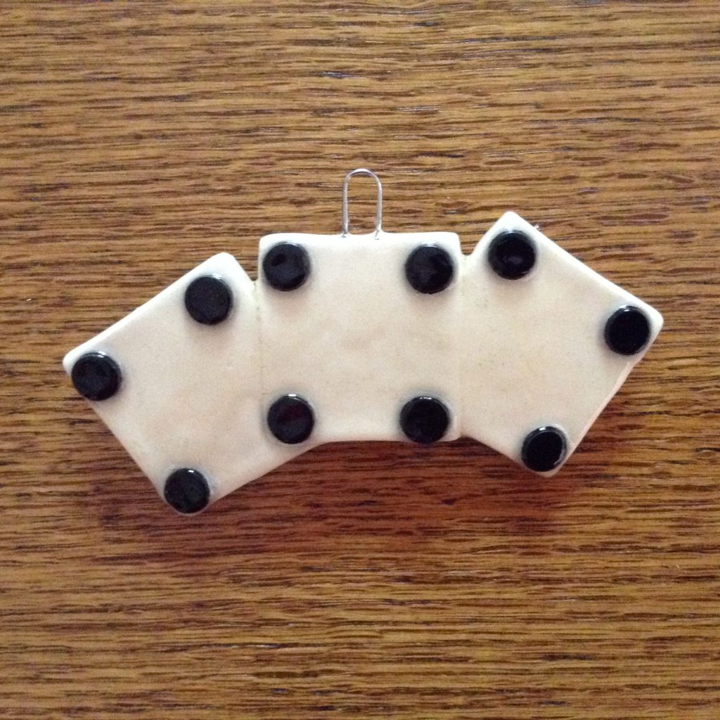A white and black pin on top of a wooden table.