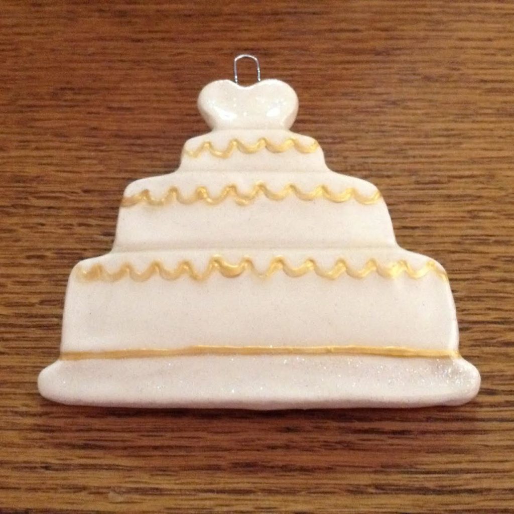 A white cake ornament sitting on top of a wooden table.