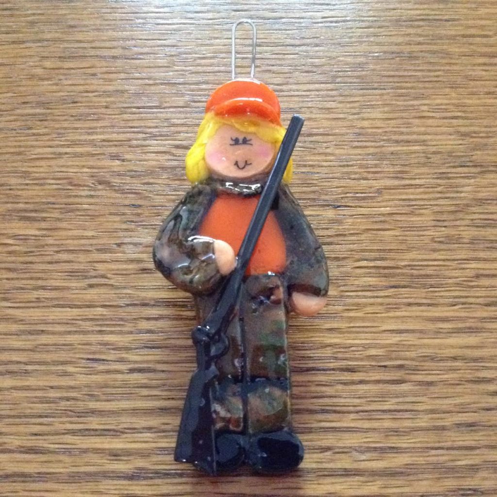 A clay figurine of a woman holding a rifle.