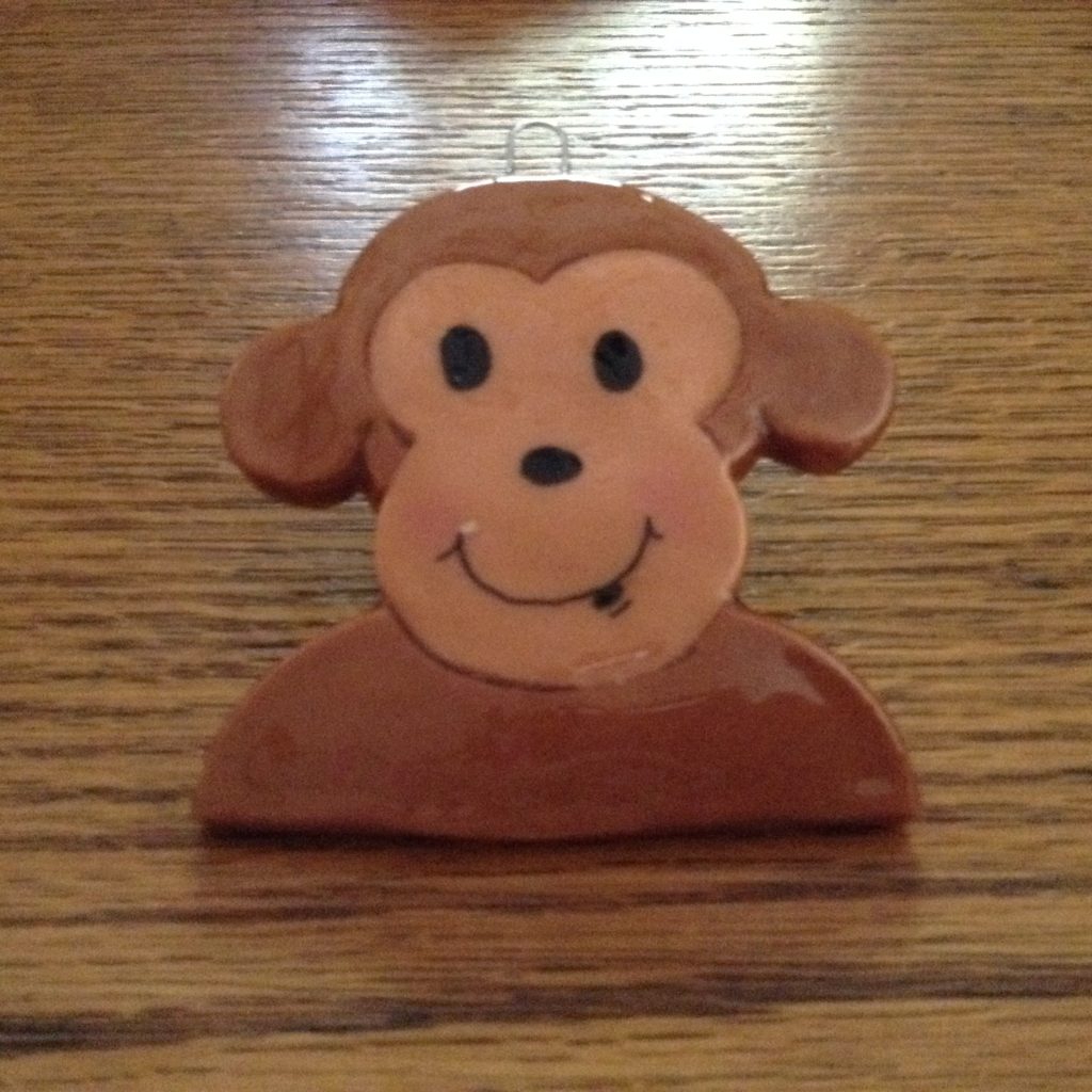 A monkey face made out of clay on top of a table.