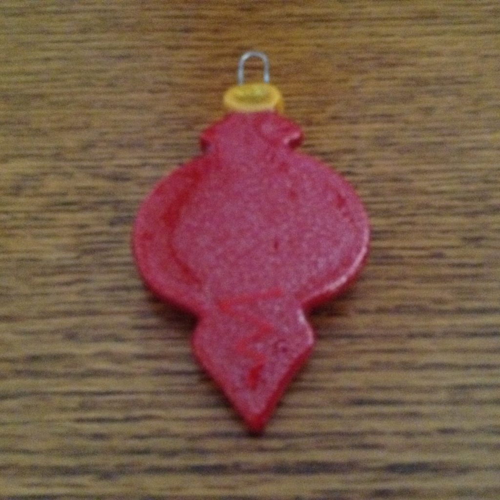 A red ornament sitting on top of a wooden table.