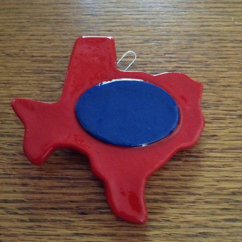 A red texas shaped object with a blue circle in the middle.