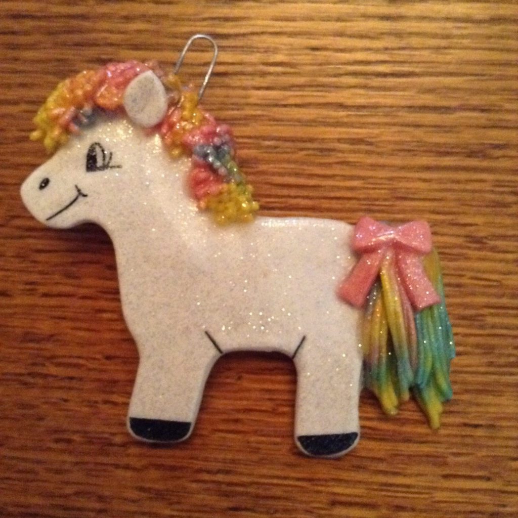 A white unicorn ornament with flowers on it.