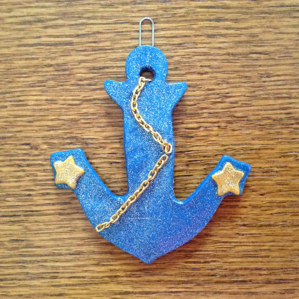 A blue anchor with gold stars and chains.