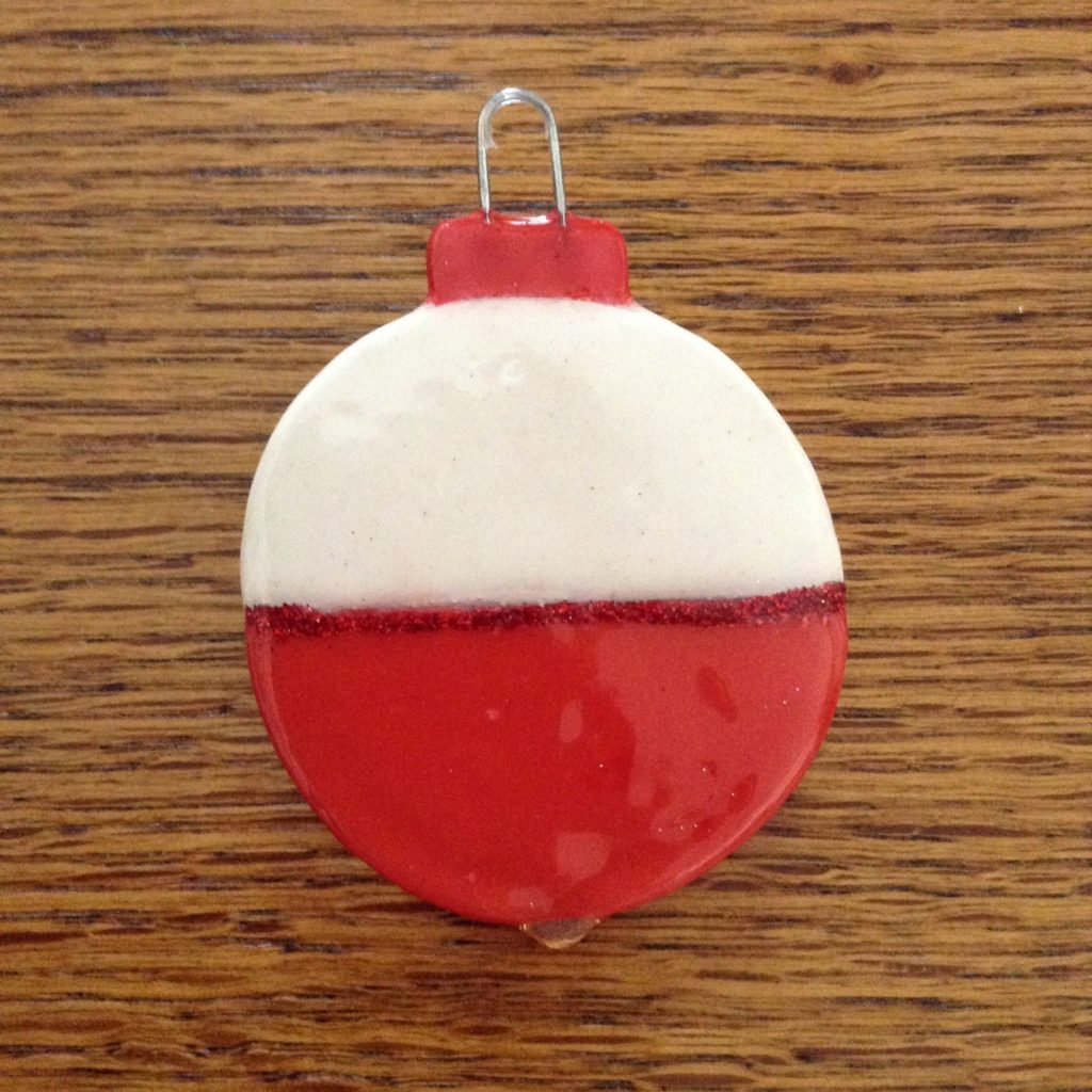 A red and white ornament sitting on top of a wooden table.