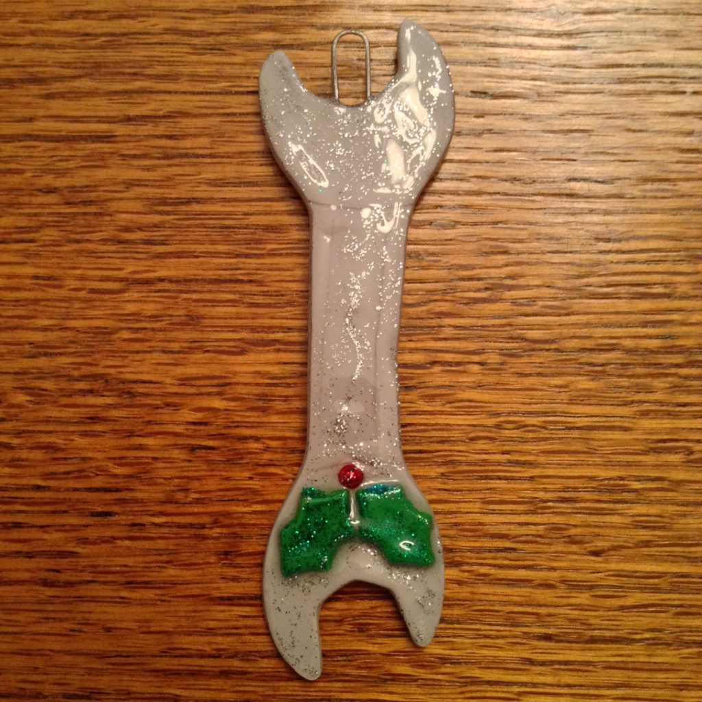 A wrench with a green leaf on it.