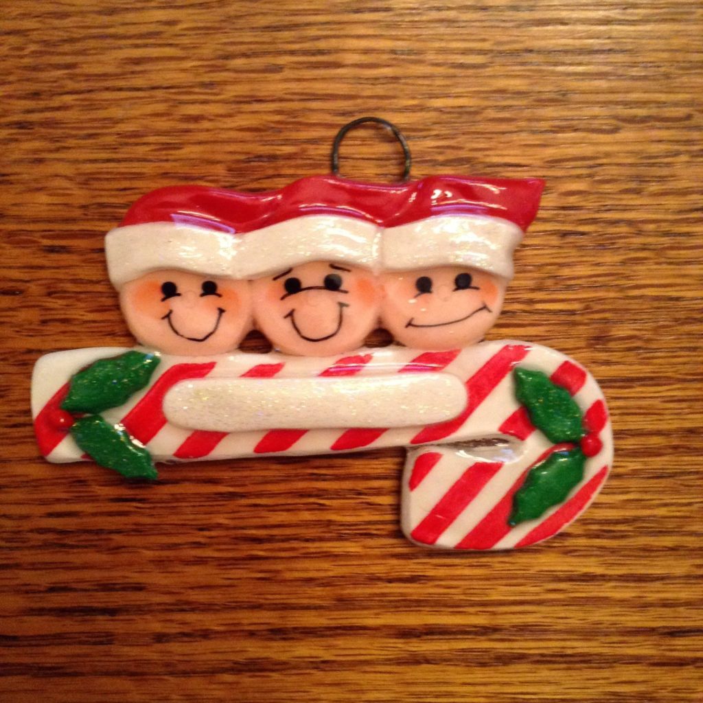 A christmas ornament with three faces on it.