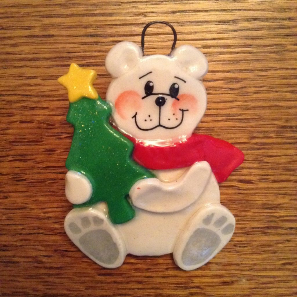 A white bear ornament with a christmas tree.