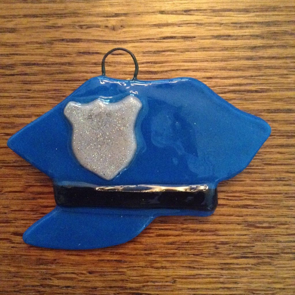 A blue and white police officer 's hat ornament.
