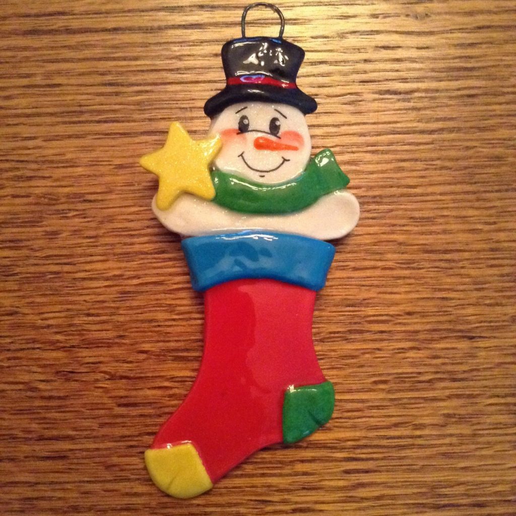 A christmas stocking ornament with a snowman on it.