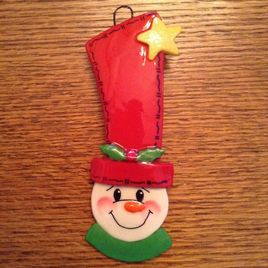 A snowman ornament hanging on the wall.