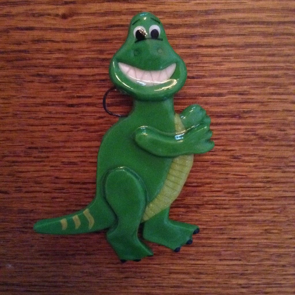 A green alligator with a smile on its face.
