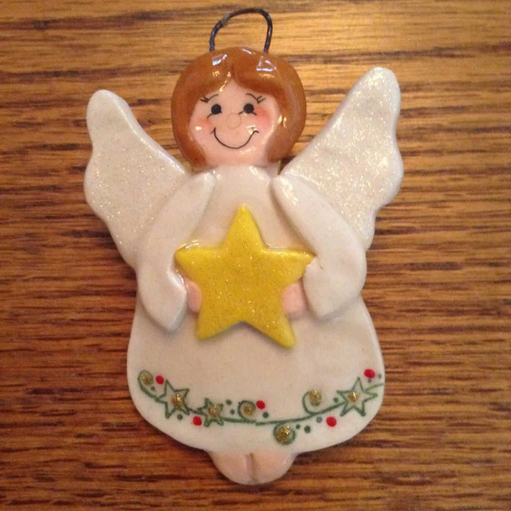 A ceramic angel ornament with a yellow star.