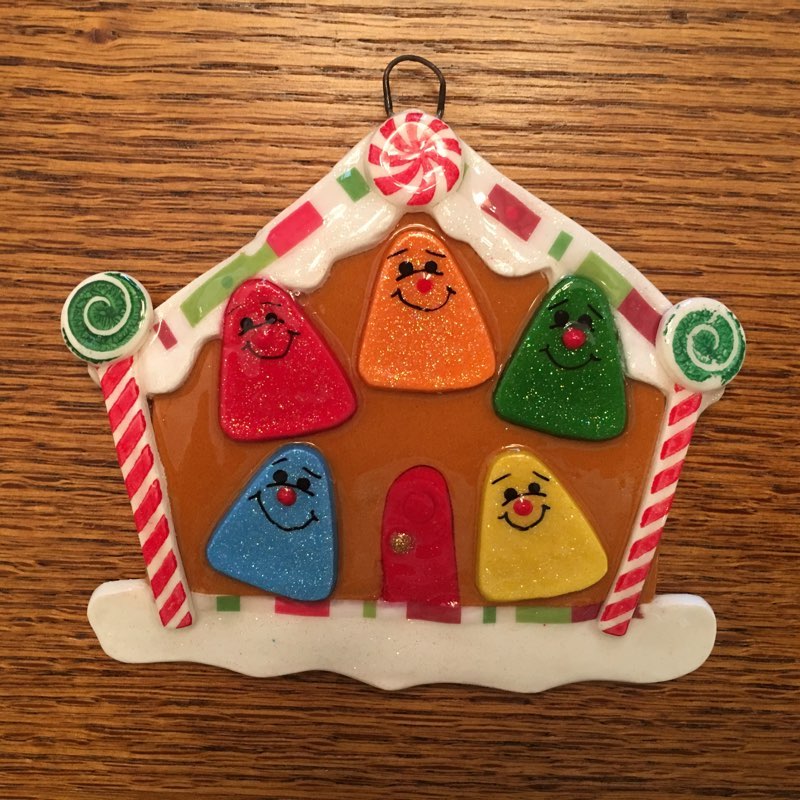 A gingerbread house ornament with candy on it.