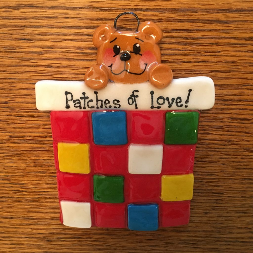 A bear ornament that says patches of love