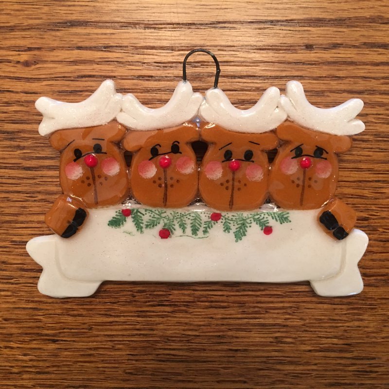 A family of four reindeer ornament hanging on the wall.