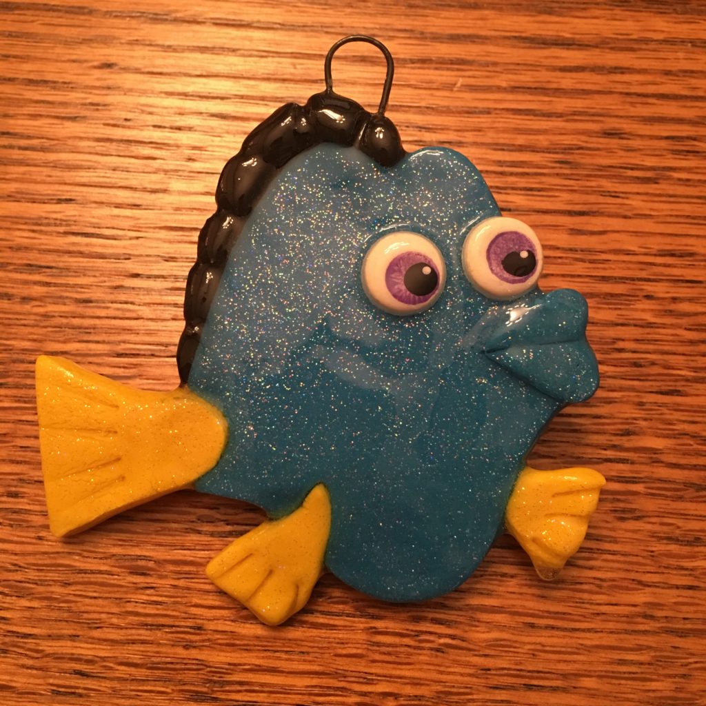A blue fish ornament with yellow eyes and black hair.