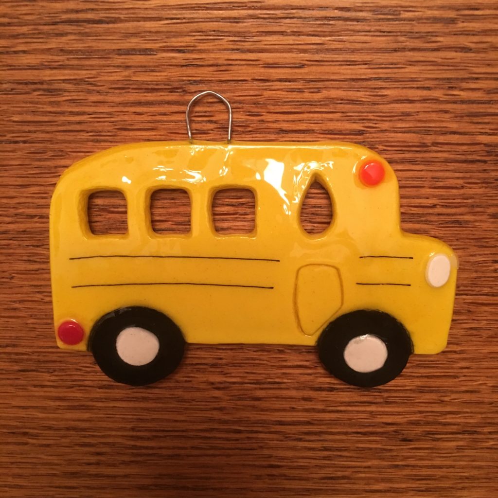 A yellow school bus ornament hanging on the wall.