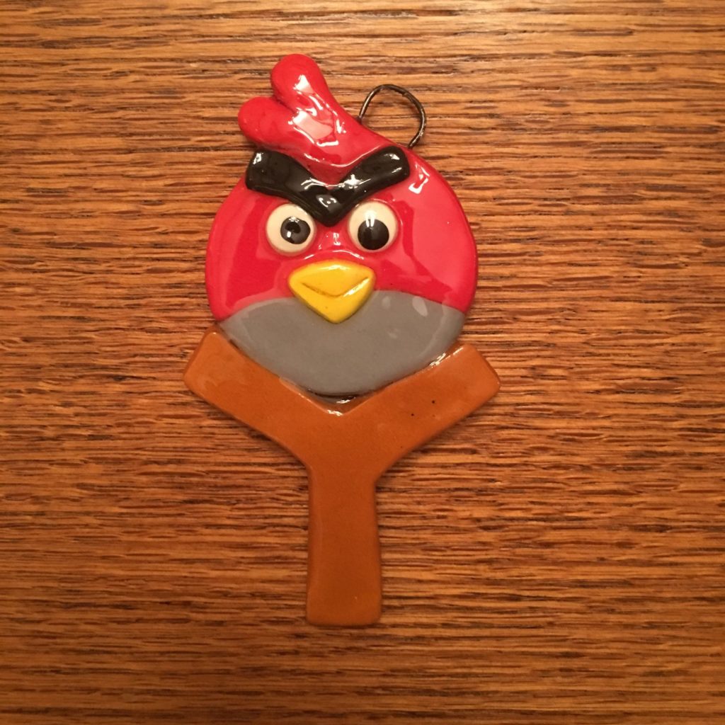 A red angry bird key chain hanging on the wall.