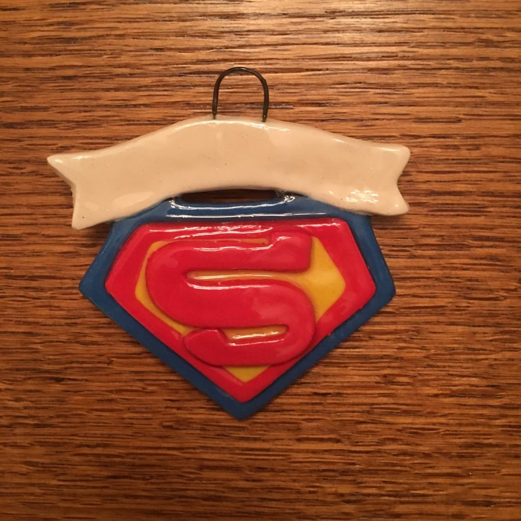 A superman ornament hanging on the wall.